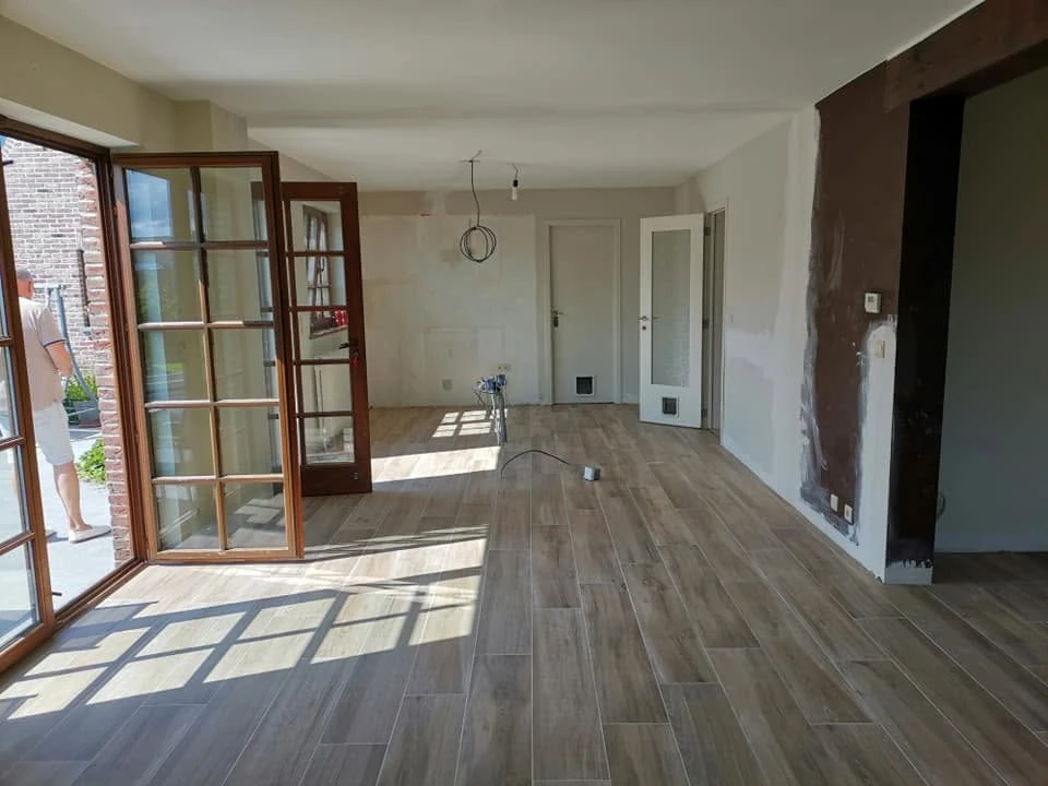 Transformation intérieure : volumes ouverts et sol carrelé du chantier Romain