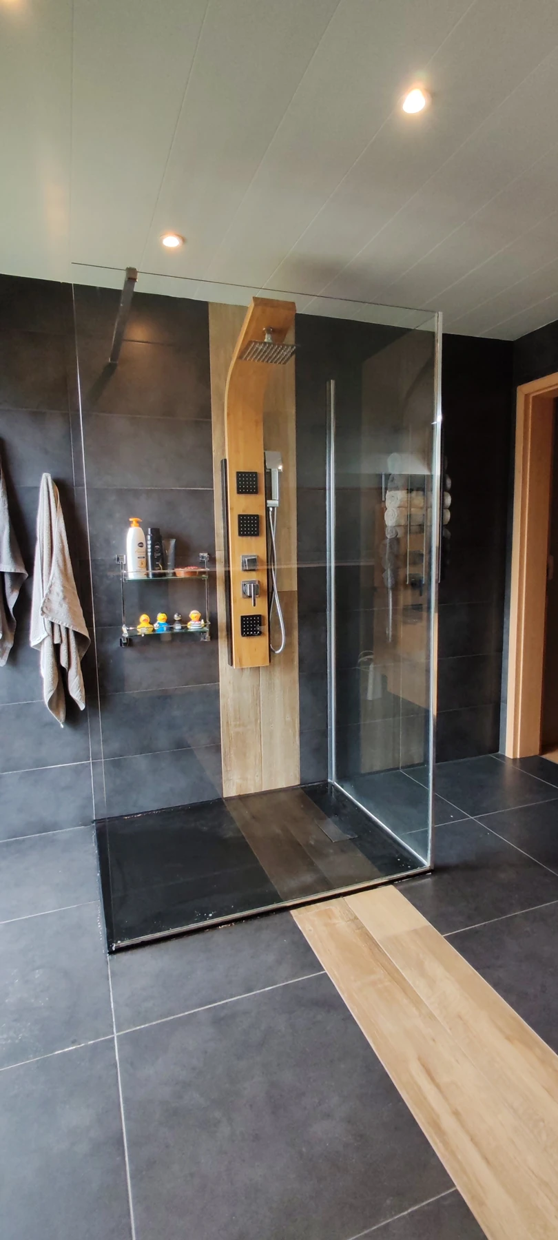 Salle de bains Huart : douche vitrée et carrelage gris et bois