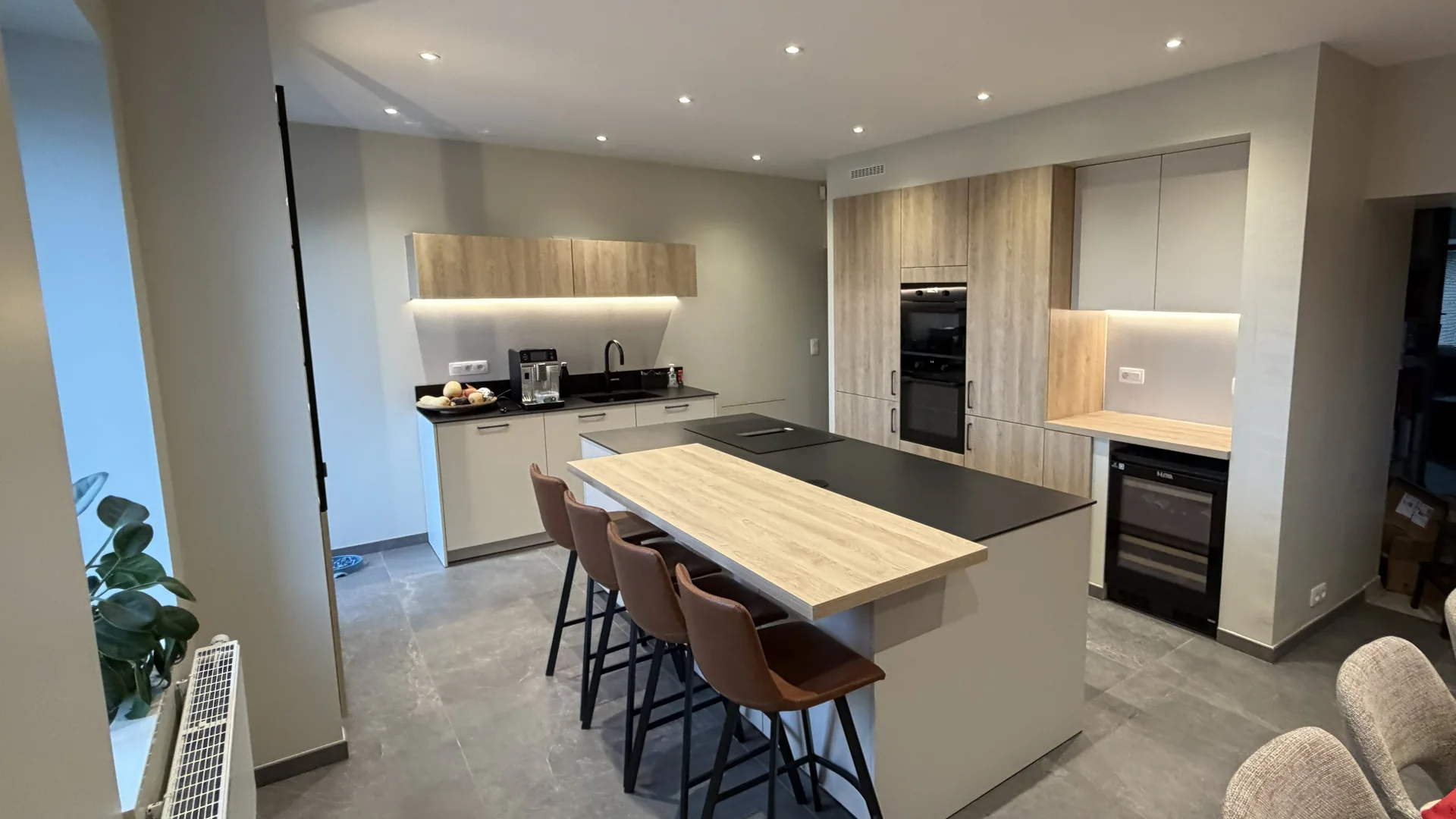 Cuisine contemporaine terminée avec îlot central, carrelage et éclairages encastrés