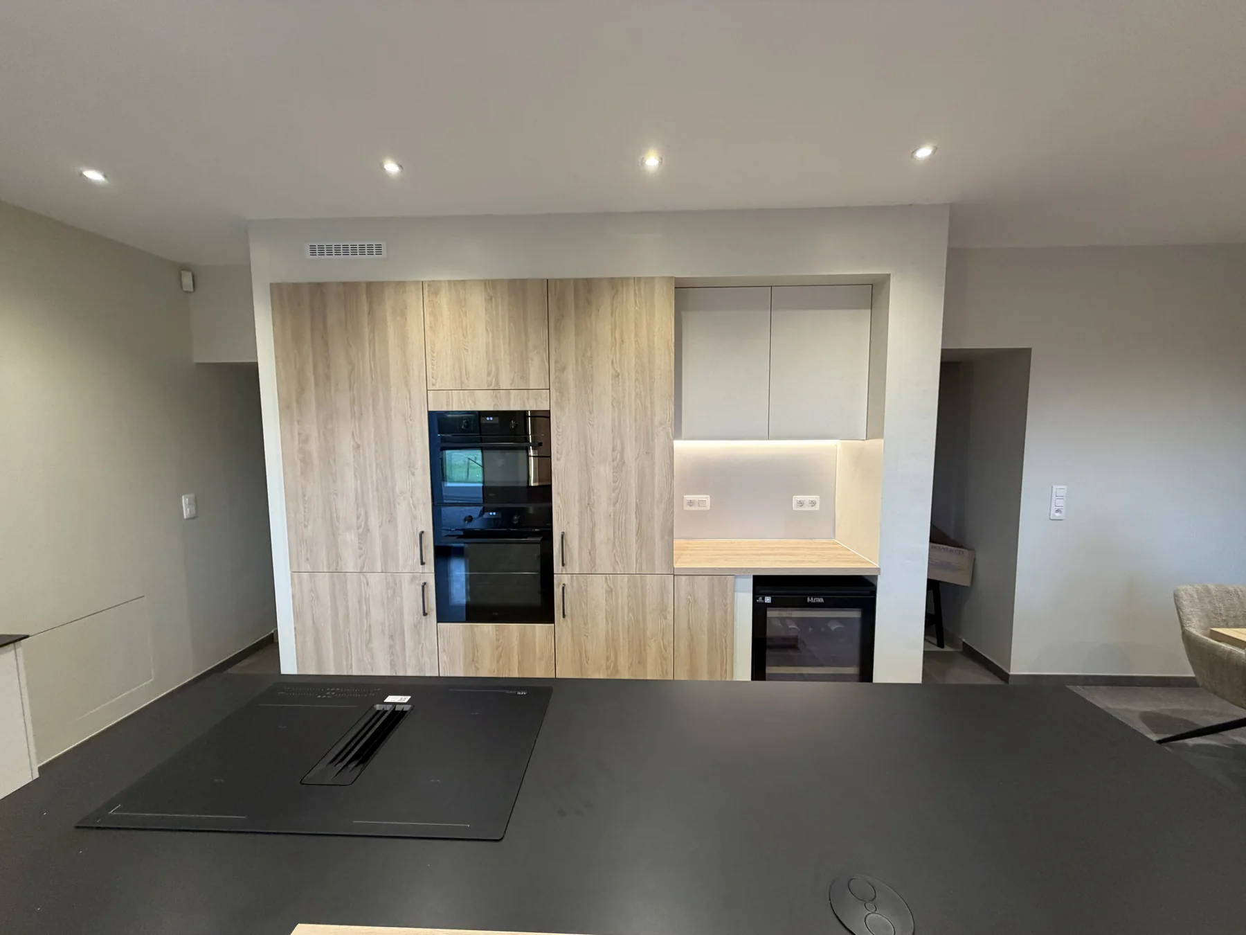 Cuisine contemporaine avec colonnes en bois clair et appareils électroménagers intégrés
