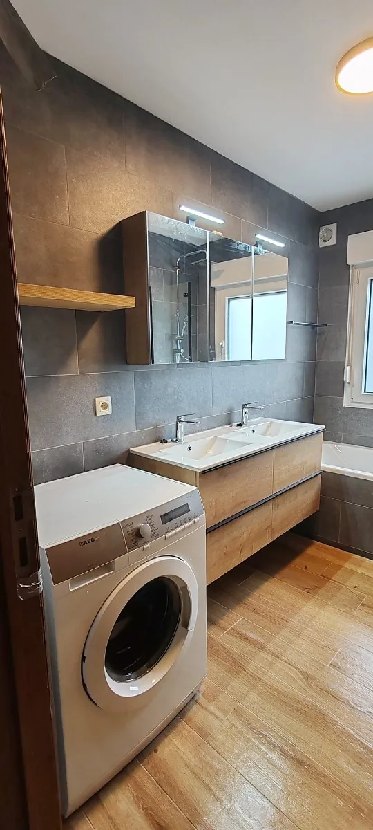 Salle de bains avec mobilier en bois et carrelage gris